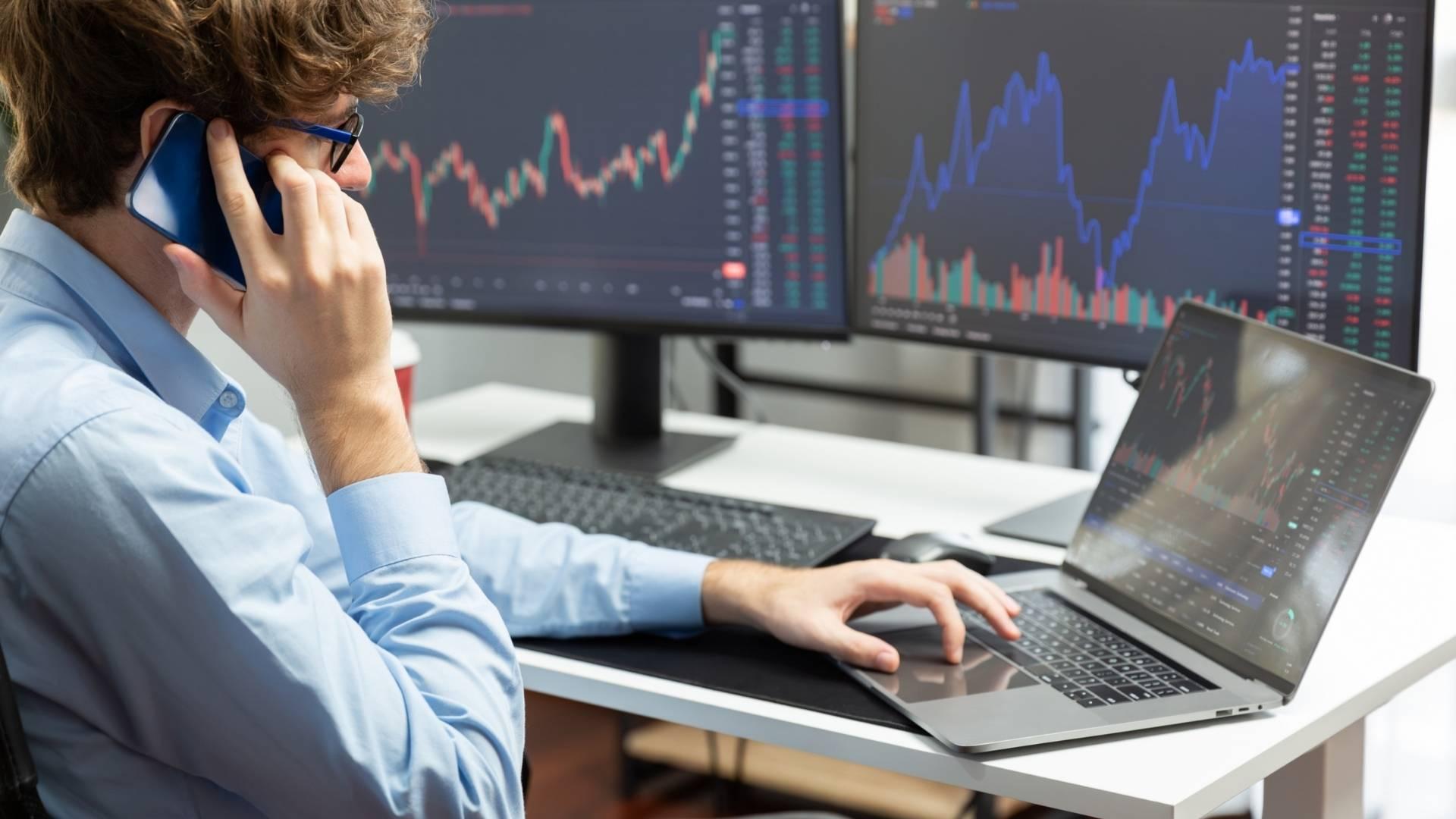 An advisor reviewing transfer details by phone at a desk