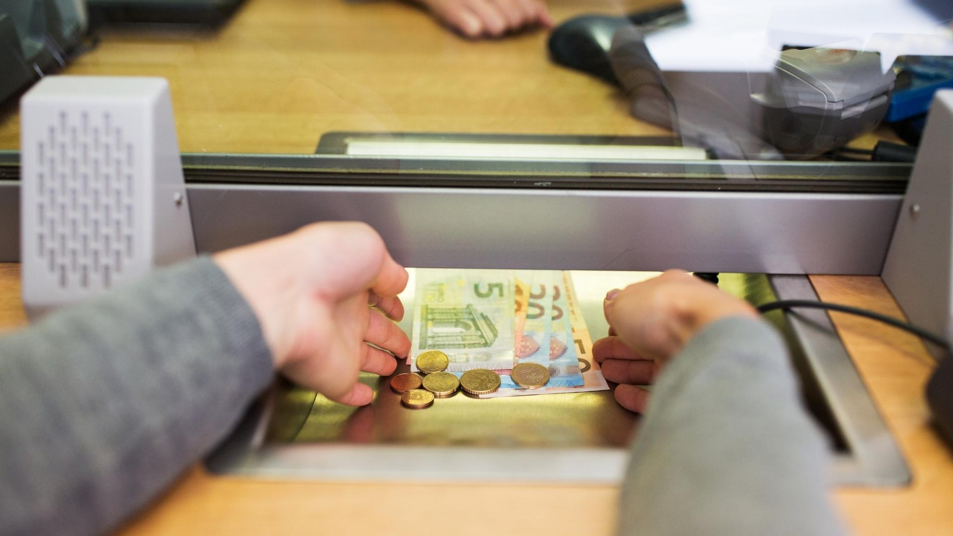 Cash being counted through a currency counter at an exchange service desk
